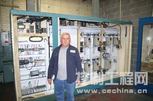 Jonathan Payton stands in front of the new finishing line control cabinet